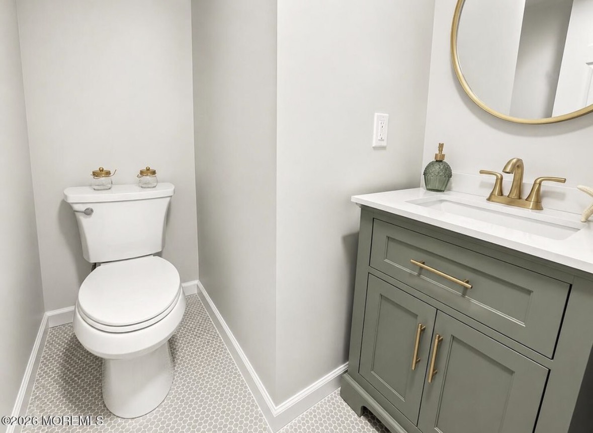 Powder room with green vanity and brass fixtures